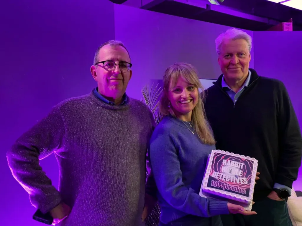 The team celebrating 100 episodes with cake!